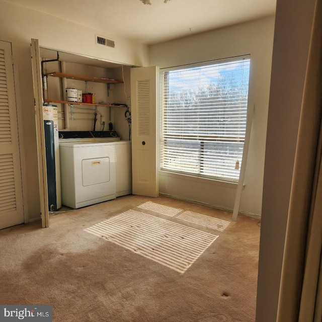 laundry area featuring laundry area, washer / clothes dryer, visible vents, and light colored carpet