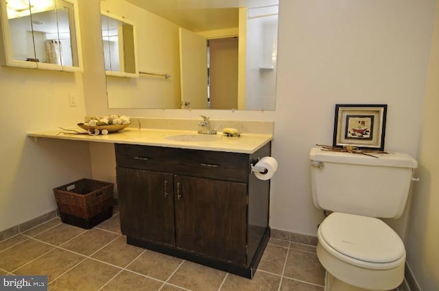 bathroom featuring toilet, vanity, baseboards, and tile patterned floors