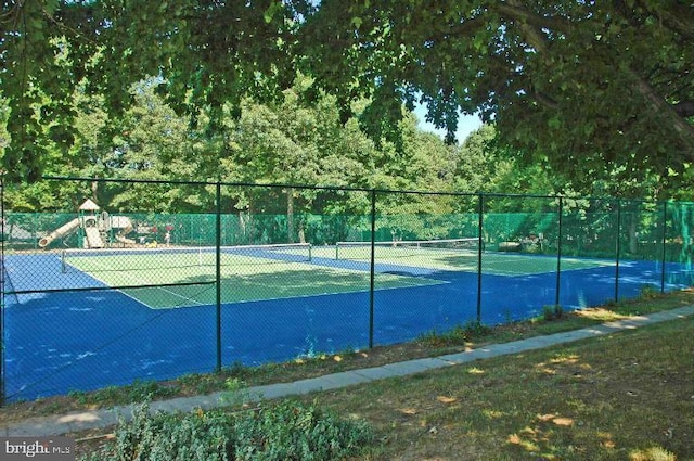 view of tennis court with fence and playground community