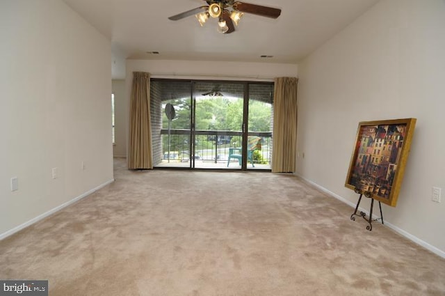 carpeted empty room featuring a ceiling fan and baseboards