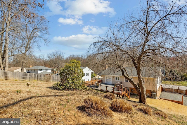 view of yard with central air condition unit, fence, and a wooden deck