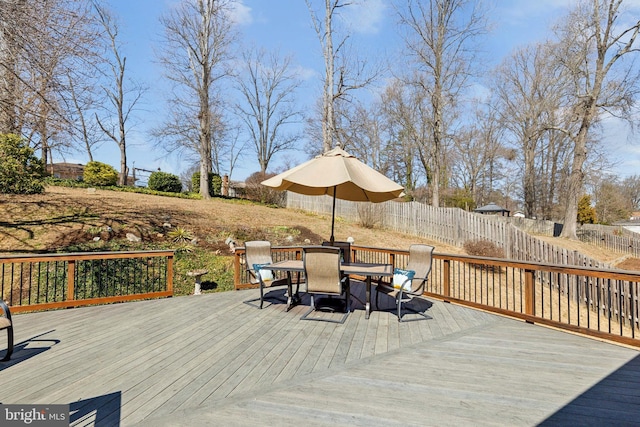 deck featuring outdoor dining area and fence