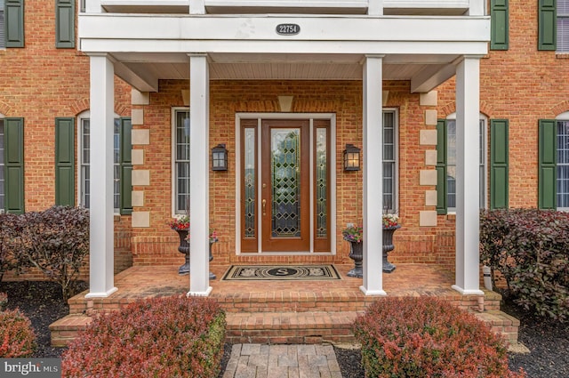 entrance to property featuring brick siding