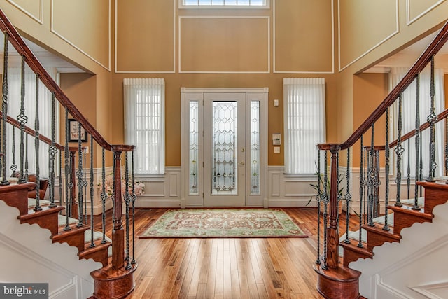 entryway featuring hardwood / wood-style flooring, a decorative wall, and stairway