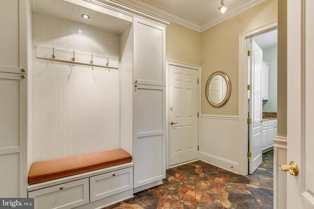 mudroom with wainscoting, stone finish flooring, and crown molding