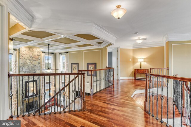 hallway featuring an upstairs landing, ornamental molding, and wood finished floors