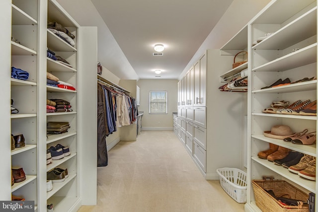 spacious closet with visible vents and light colored carpet