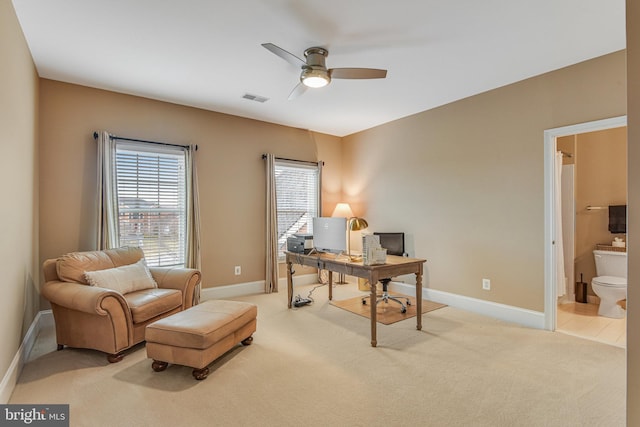 home office featuring visible vents, light carpet, baseboards, and ceiling fan