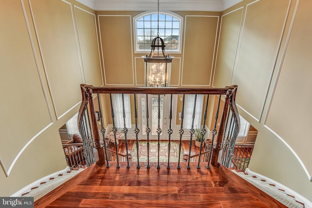 stairs featuring a chandelier and a decorative wall