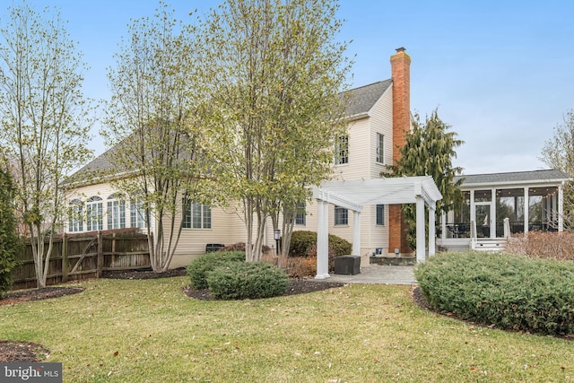 view of front facade featuring a front yard, fence, a pergola, a sunroom, and a patio area