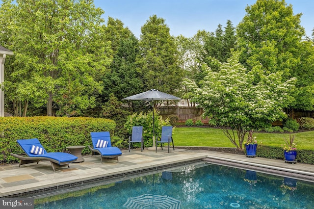 view of swimming pool with a patio area, a fenced in pool, fence, and a lawn