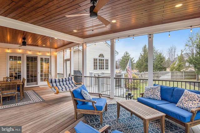 sunroom featuring beam ceiling, wooden ceiling, and a ceiling fan