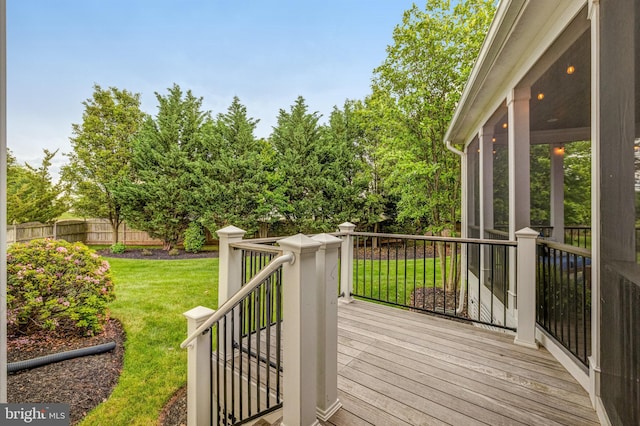 wooden terrace with fence, a yard, and a sunroom