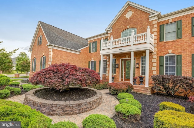 georgian-style home with brick siding and a shingled roof