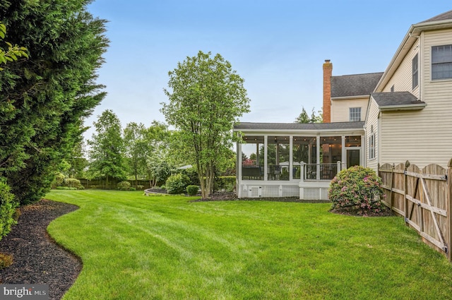 view of yard featuring a fenced backyard and a sunroom