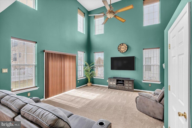 living area with baseboards, carpet, and a ceiling fan