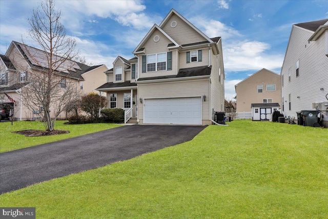 view of front of home featuring aphalt driveway, cooling unit, a front lawn, and a garage