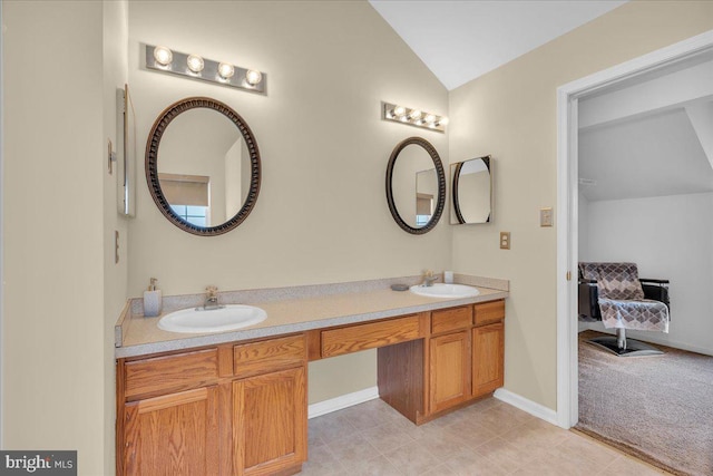 full bath with vaulted ceiling, double vanity, baseboards, and a sink