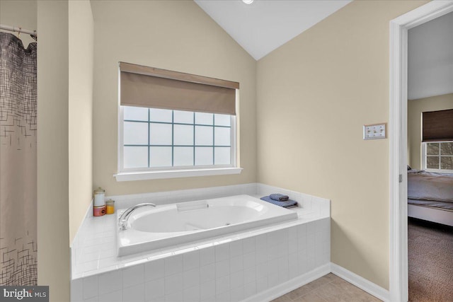 bathroom with tile patterned floors, a garden tub, and vaulted ceiling