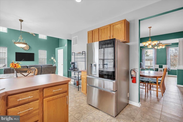 kitchen featuring light countertops, decorative light fixtures, visible vents, and stainless steel fridge