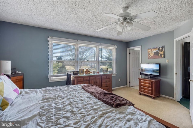 bedroom featuring a ceiling fan, baseboards, a textured ceiling, and light colored carpet