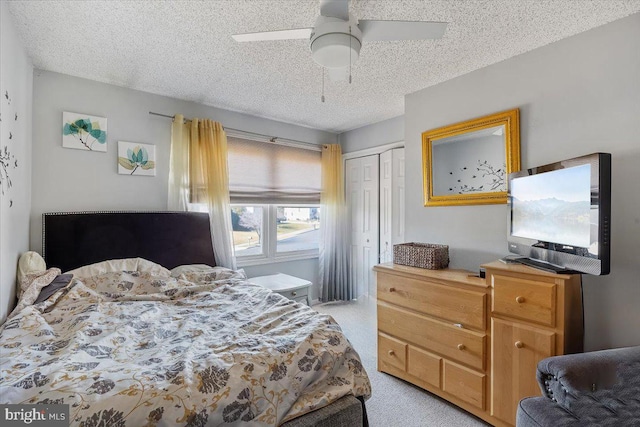 bedroom with light carpet, ceiling fan, a closet, and a textured ceiling