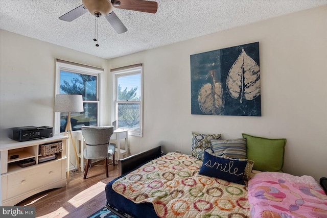 bedroom featuring ceiling fan, a textured ceiling, and wood finished floors