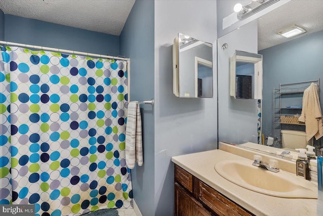 full bathroom featuring a textured ceiling, vanity, and a shower with curtain