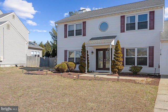 view of front of home with a shingled roof, a chimney, fence, french doors, and a front lawn