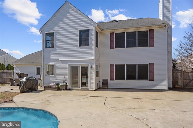 back of property with a patio area, a chimney, fence, and a fenced in pool