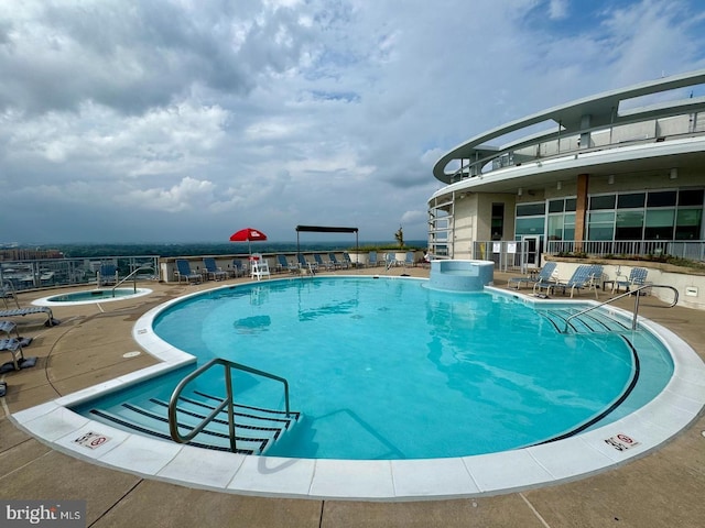 pool featuring a patio and a hot tub