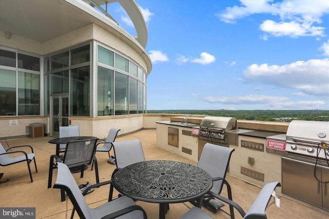 view of patio with outdoor dining space, a grill, and an outdoor kitchen