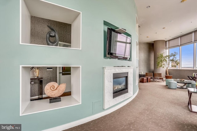 carpeted living room featuring a high end fireplace