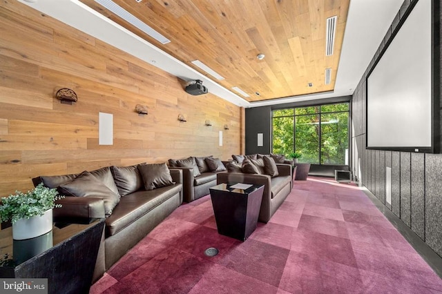 home theater featuring a tray ceiling, wooden walls, wood ceiling, and visible vents