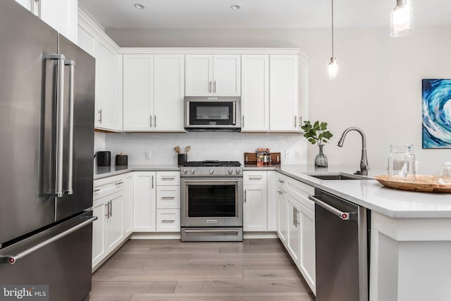 kitchen with a sink, wood finished floors, backsplash, and stainless steel appliances