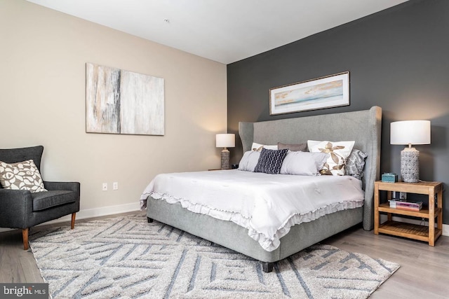 bedroom featuring baseboards and wood finished floors