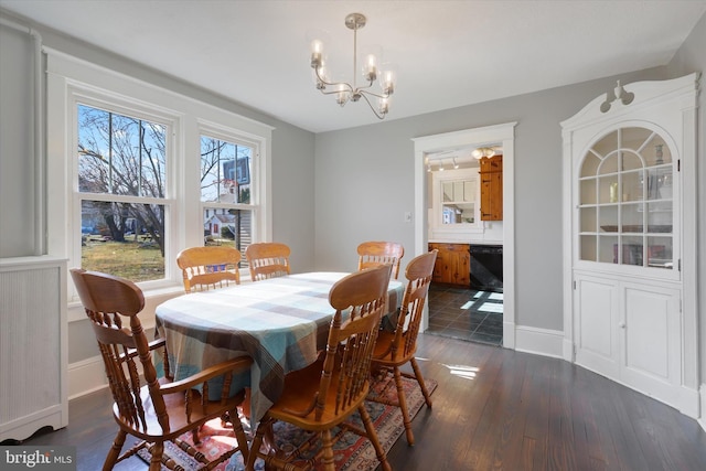 dining space featuring dark wood-style floors, a chandelier, and baseboards