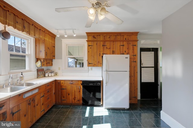 kitchen featuring ceiling fan, light countertops, black dishwasher, freestanding refrigerator, and a sink