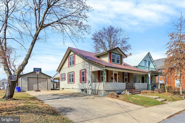 view of front of home with a porch, a detached garage, driveway, and an outdoor structure