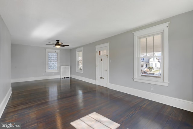 unfurnished living room featuring a ceiling fan, wood finished floors, and baseboards