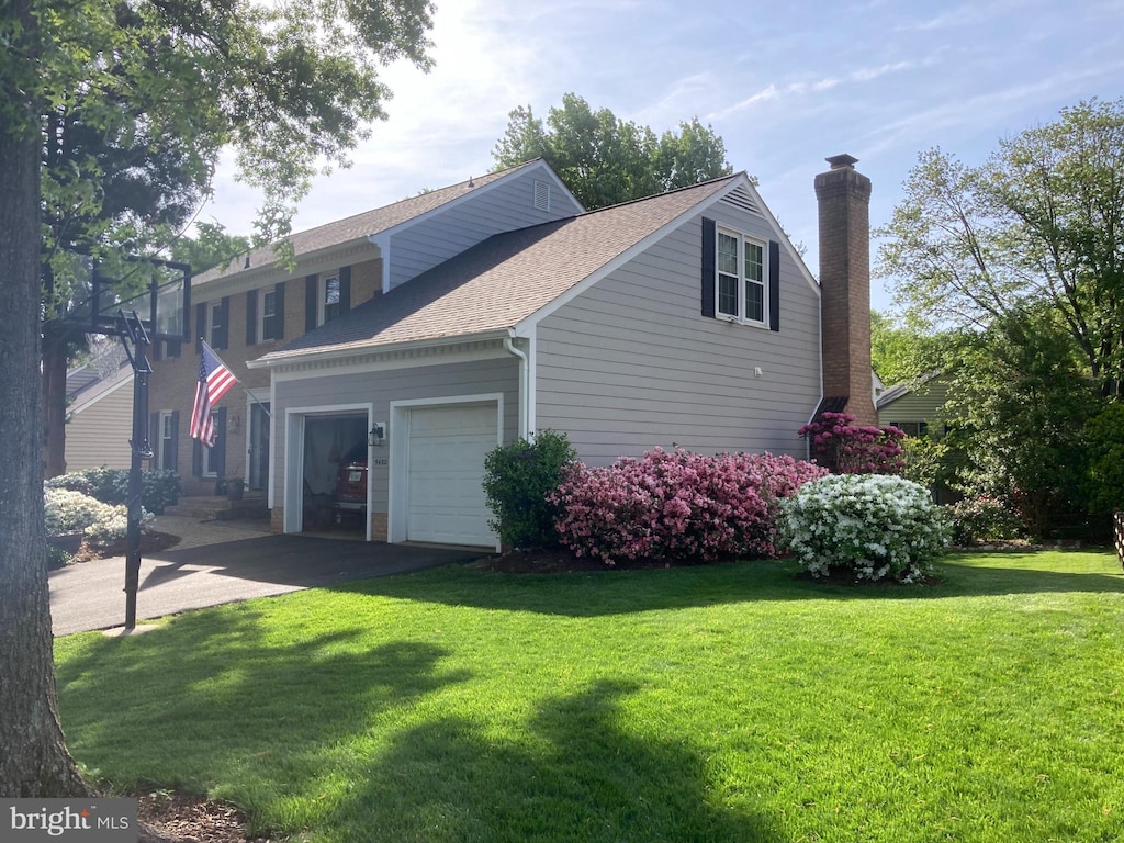 view of home's exterior with driveway, an attached garage, a shingled roof, a chimney, and a lawn