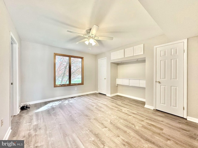 unfurnished bedroom featuring light wood finished floors, a ceiling fan, and baseboards