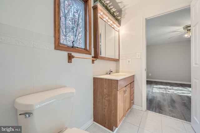 bathroom with ceiling fan, vanity, tile patterned flooring, and tile walls