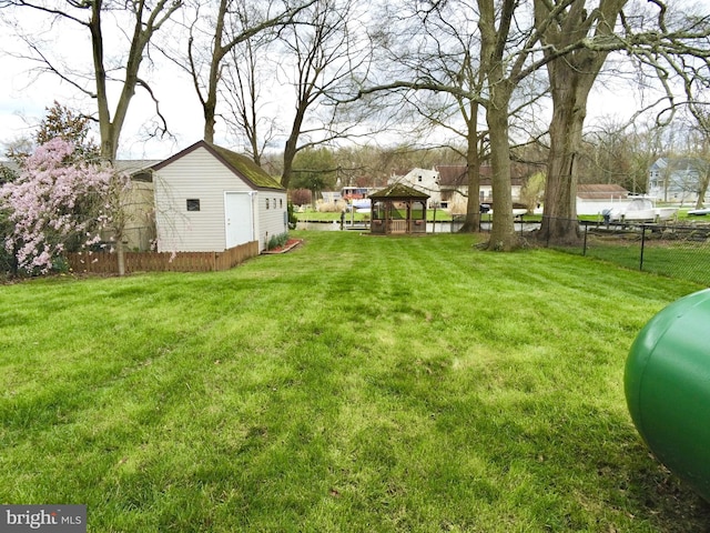 view of yard with a gazebo, an outdoor structure, and fence