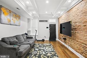 living room with crown molding, brick wall, wood finished floors, coffered ceiling, and beamed ceiling