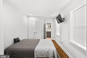 bedroom featuring ensuite bathroom, recessed lighting, wood finished floors, and baseboards