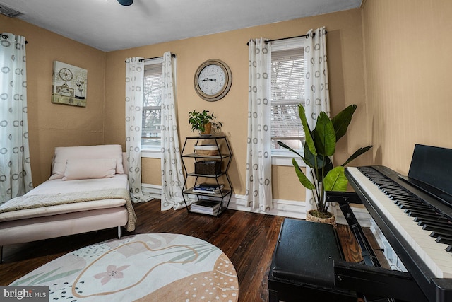 living area with dark wood-style floors, visible vents, and baseboards