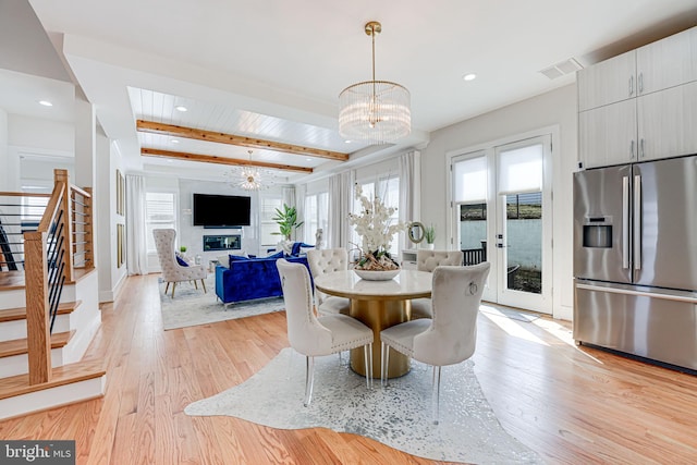 dining space featuring visible vents, stairway, light wood-type flooring, beam ceiling, and a notable chandelier