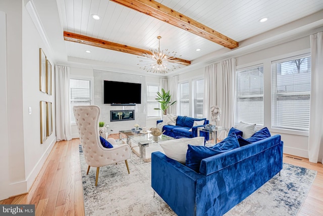 living room featuring beam ceiling, plenty of natural light, and light wood finished floors