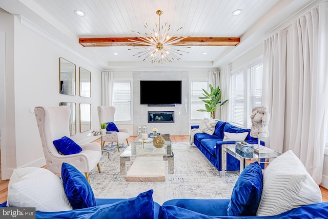 living area featuring wood ceiling, a notable chandelier, wood finished floors, and a large fireplace